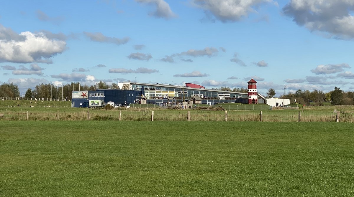 Bild der Multimar-Wattforums aus 500m Entfernung mit Wolken und Weiden